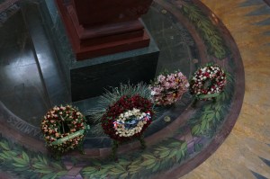 Fresh floral wreaths are present at his tomb